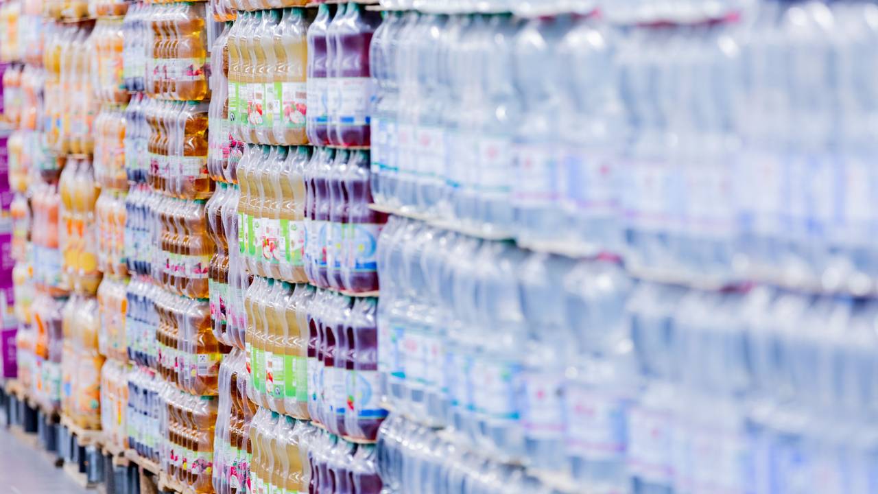 Plastikflaschen stehen in einem Supermarkt auf Paletten.
