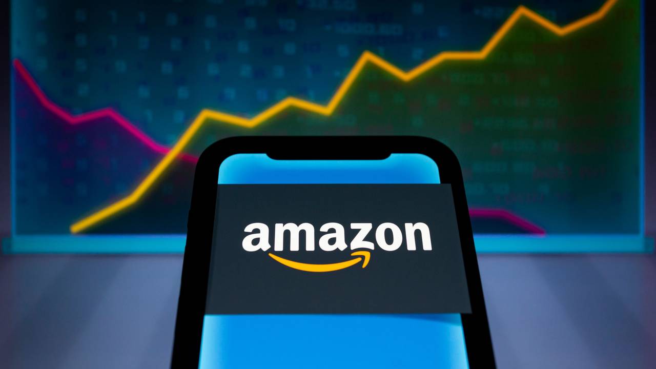 Das Logo von Amazon wird auf einem Smartphone angezeigt, im Hintergrund sind abstrakte Diagramme mit steigenden und fallenden Linien und Zahlen zu sehen, hier im Juli 2022 in Paraguay