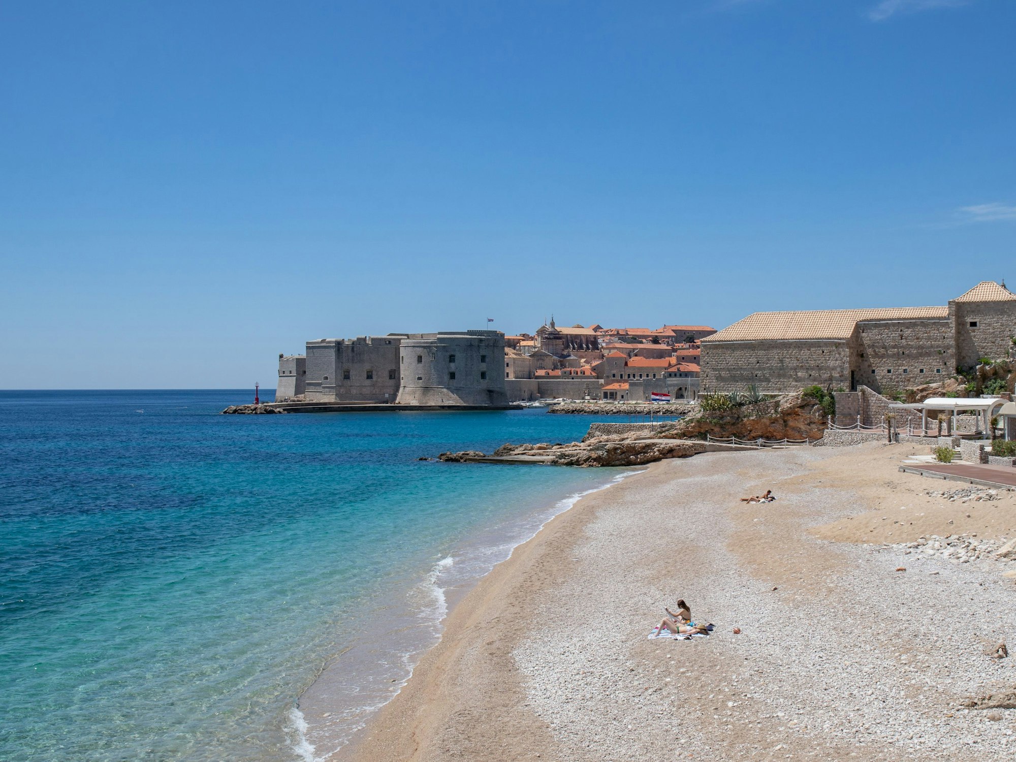 Vier Personen sonnen sich an der Adria an einem Strand, hier im Mai 2020.