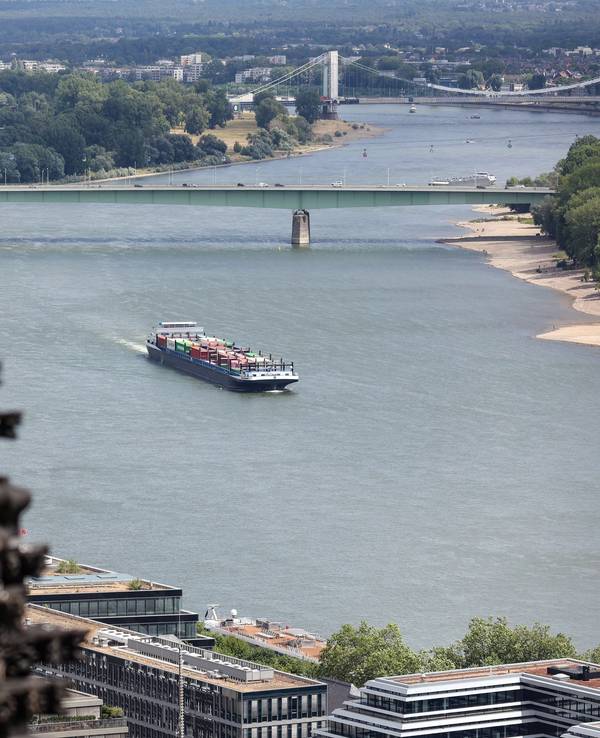 Ein Transport-Schiff fährt auf dem Rhein. Im Vordergrund ist der Dom, im Hintergrund die Zoobrücke zu sehen.