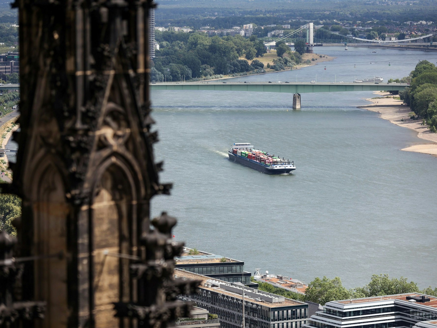 Ein Transport-Schiff fährt auf dem Rhein. Im Vordergrund ist der Dom, im Hintergrund die Zoobrücke zu sehen.