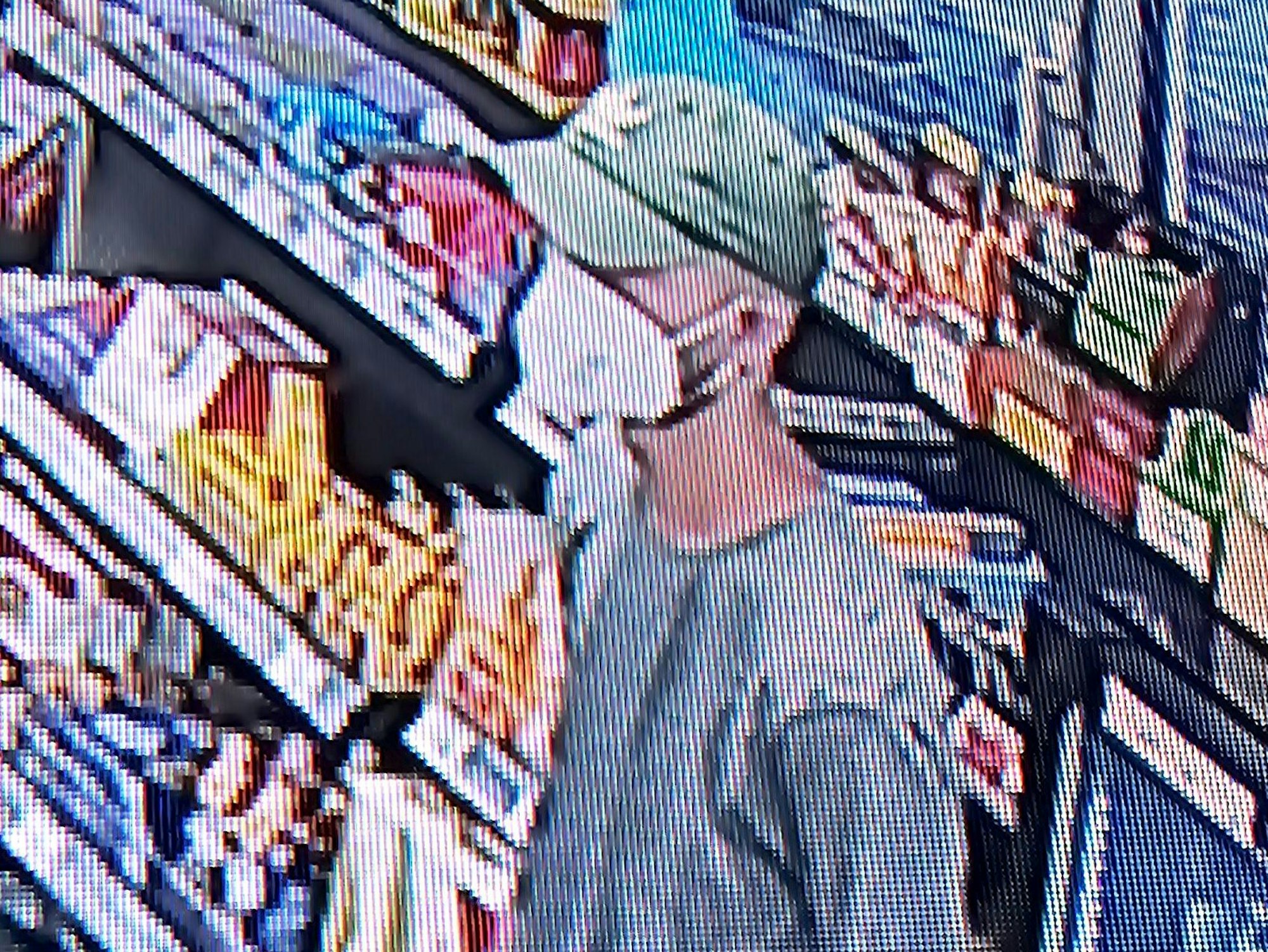 Ein Mann mit Kappe steht in einer Tankstellen vor einem Warenregal.