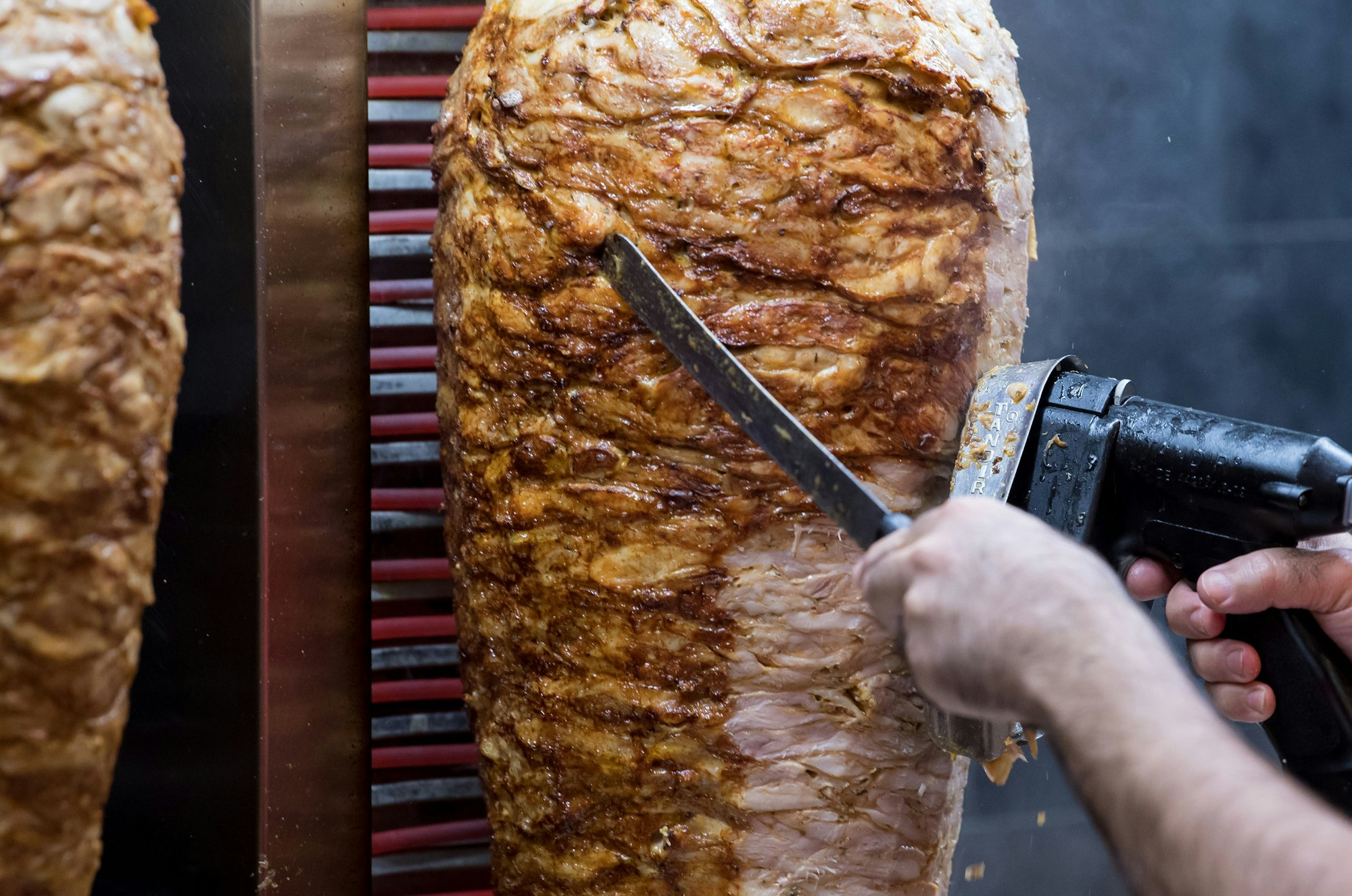 Dönerspieße drehen sich in einem Imbiss.