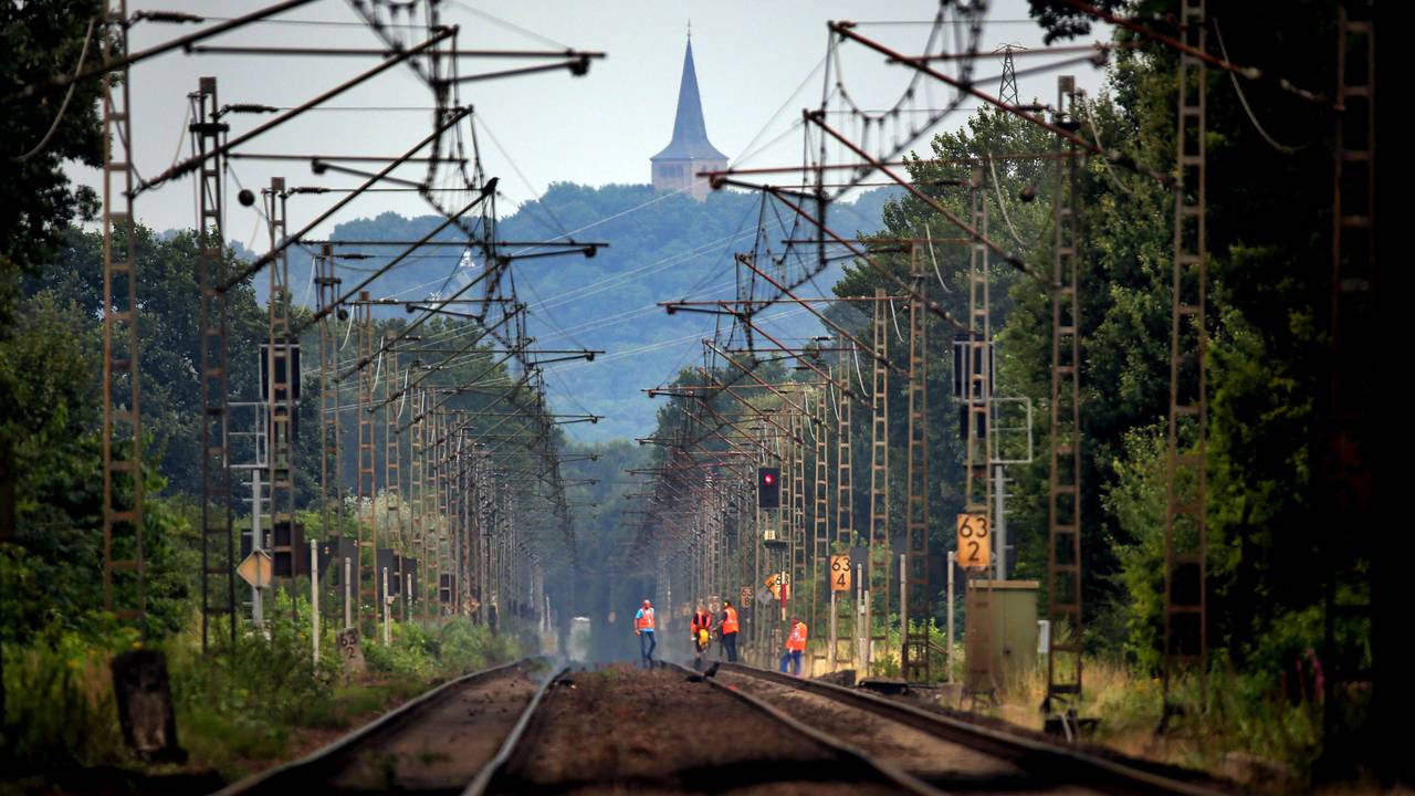 Bahn-Mitarbeitende laufen am 28. Juli 2014 unterhalb des Eltenberges über die Bahngleise.
