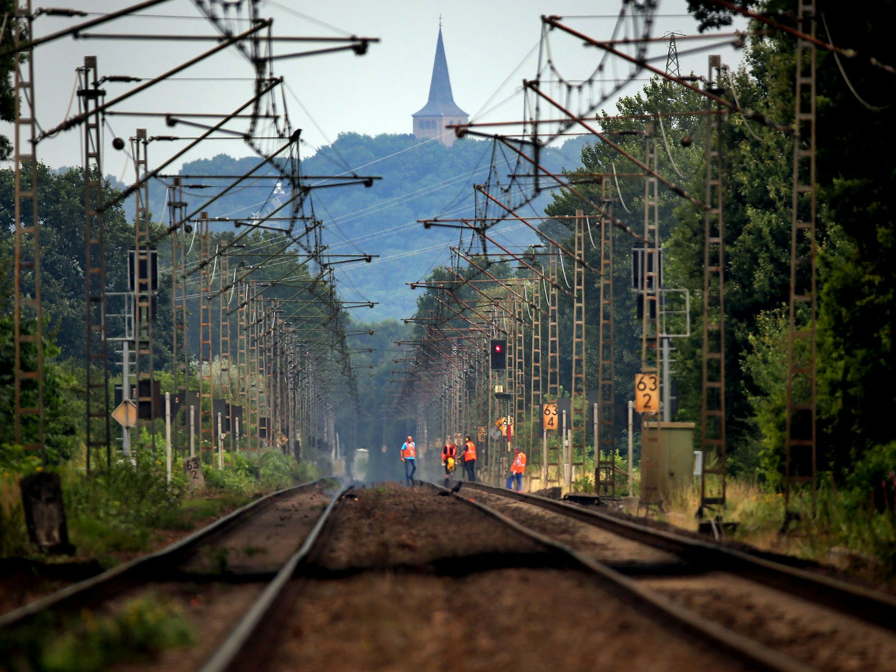 Bahn-Mitarbeitende laufen am 28. Juli 2014 unterhalb des Eltenberges über die Bahngleise.