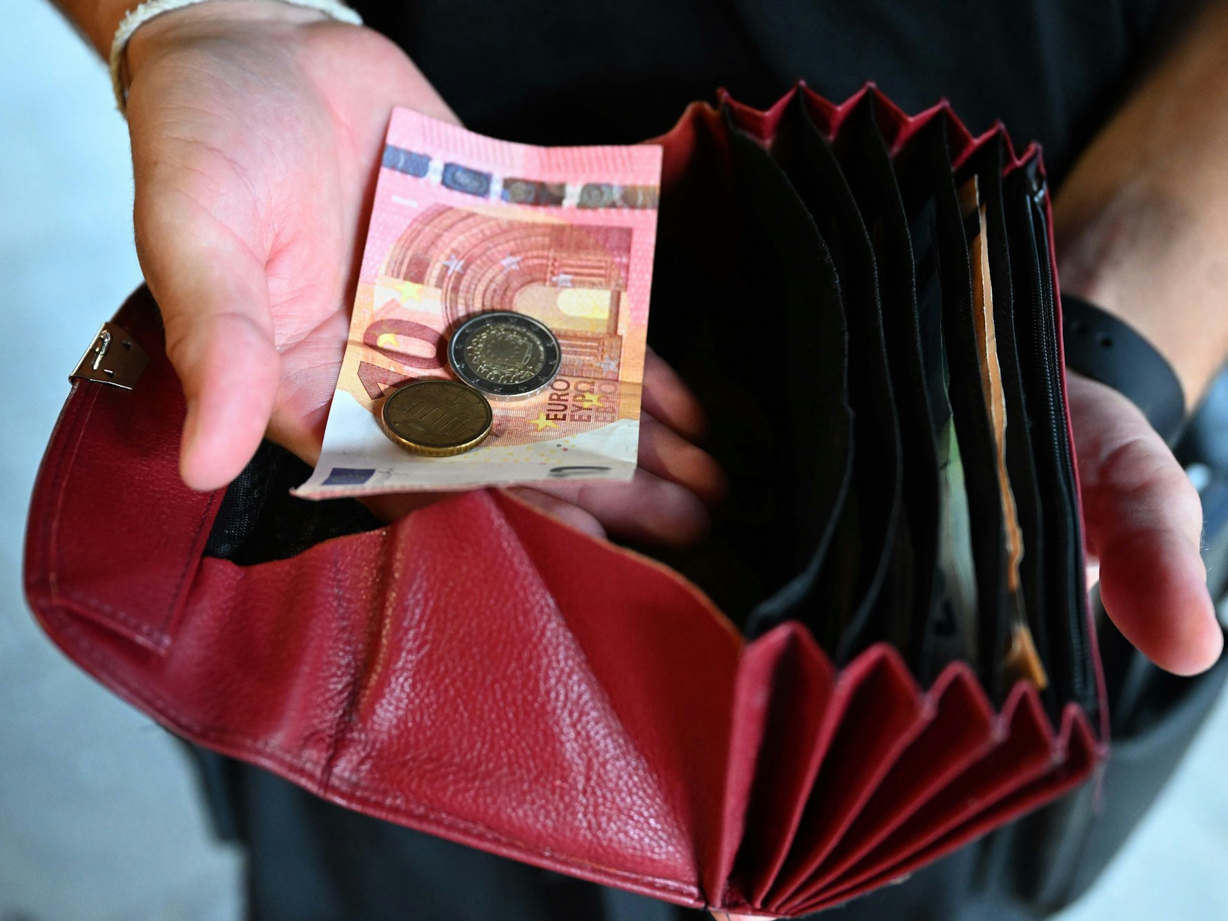 Ein Kellner mit rotem Portemonnaie und Bargeld.