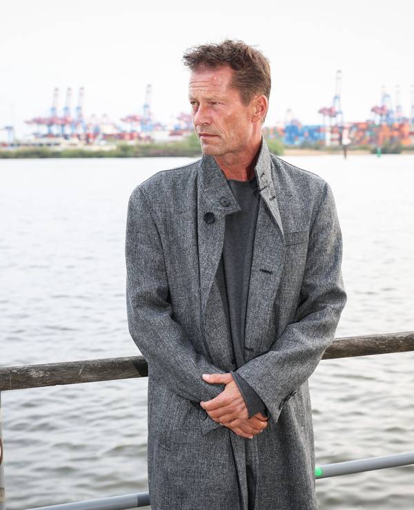 Til Schweiger posiert am Hafen für ein Foto.