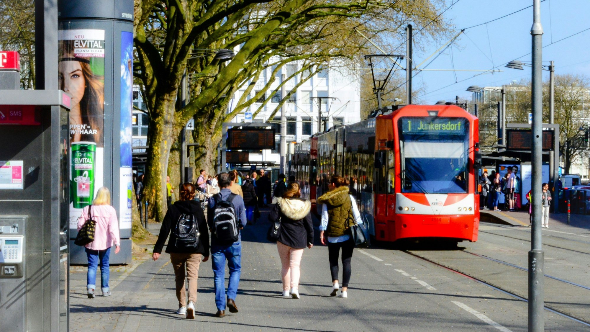 Eine Straßenbahn hält am Neumarkt, mehrere Personen gehen darauf zu.