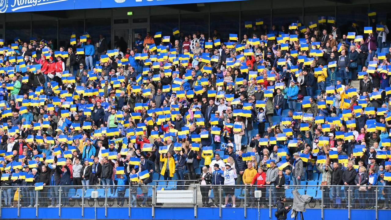 Die Zuschauer des Benefizspiels am 28. Mai 2022 stehen auf ihren Plätzen und halten Plakate mit der ukrainischen Fahne in die Höhe, während die ukrainische Nationalhymne gespielt wird.