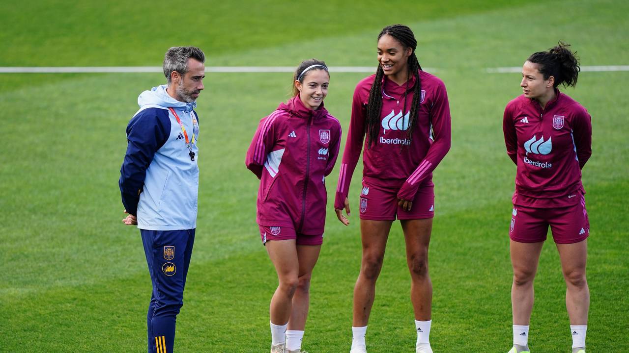 Trainer Jorge Vilda steht neben drei Nationalspielerinnen Spaniens auf dem Trainingsplatz.