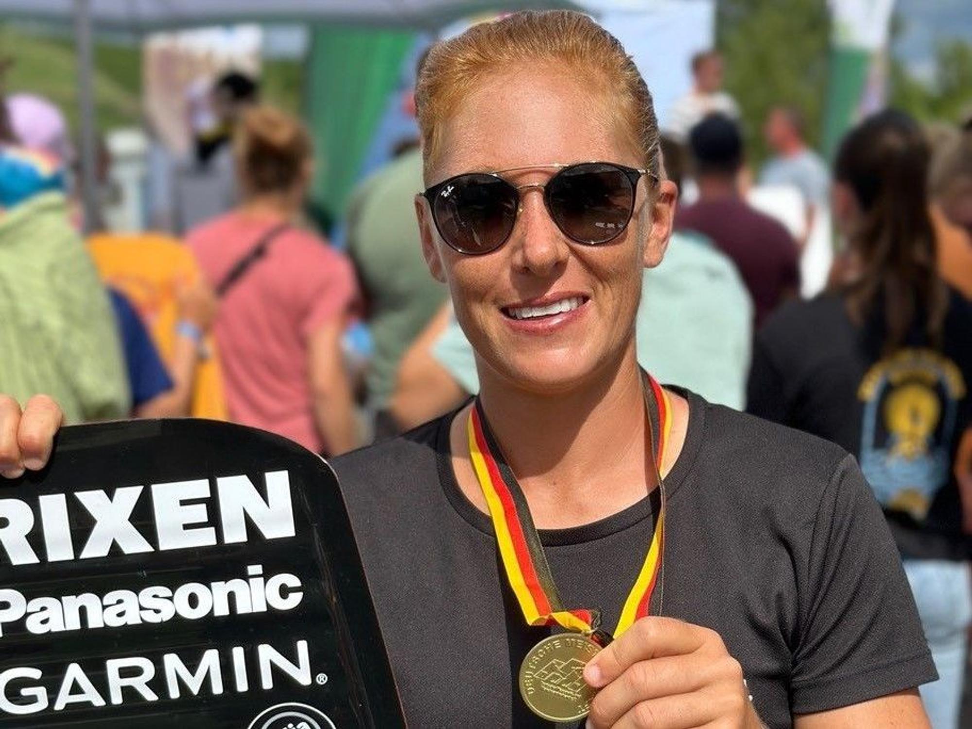 Julia Rick posiert mit ihrer Goldmedaille für die Deutsche Meisterschaft im Wakeboarding.