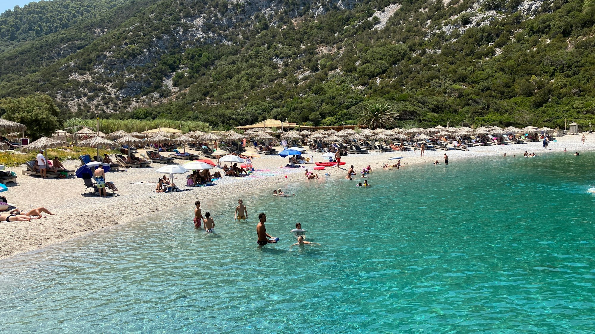 Menschen verbringen den heißen Sommertag an einem Strand auf der Sporaden-Insel Skopelos.