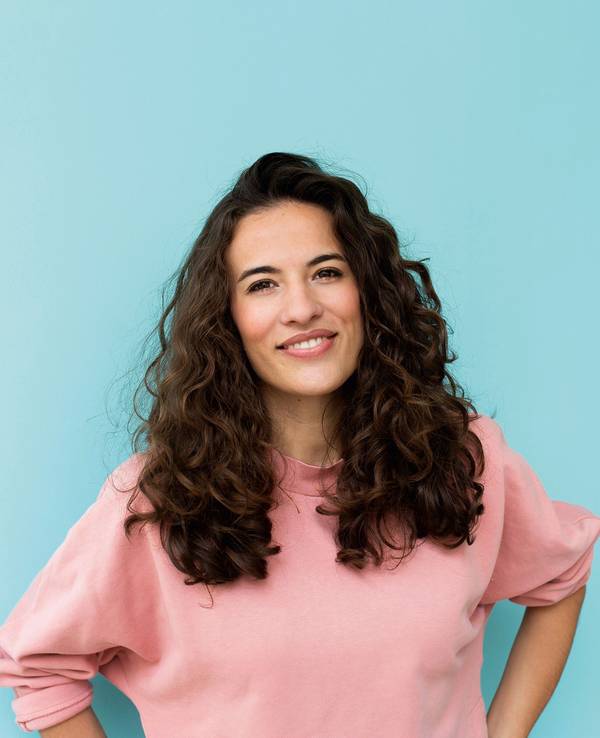 Moderatorin Mona Ameziane posiert mit leichtem Lächeln für die Kamera.