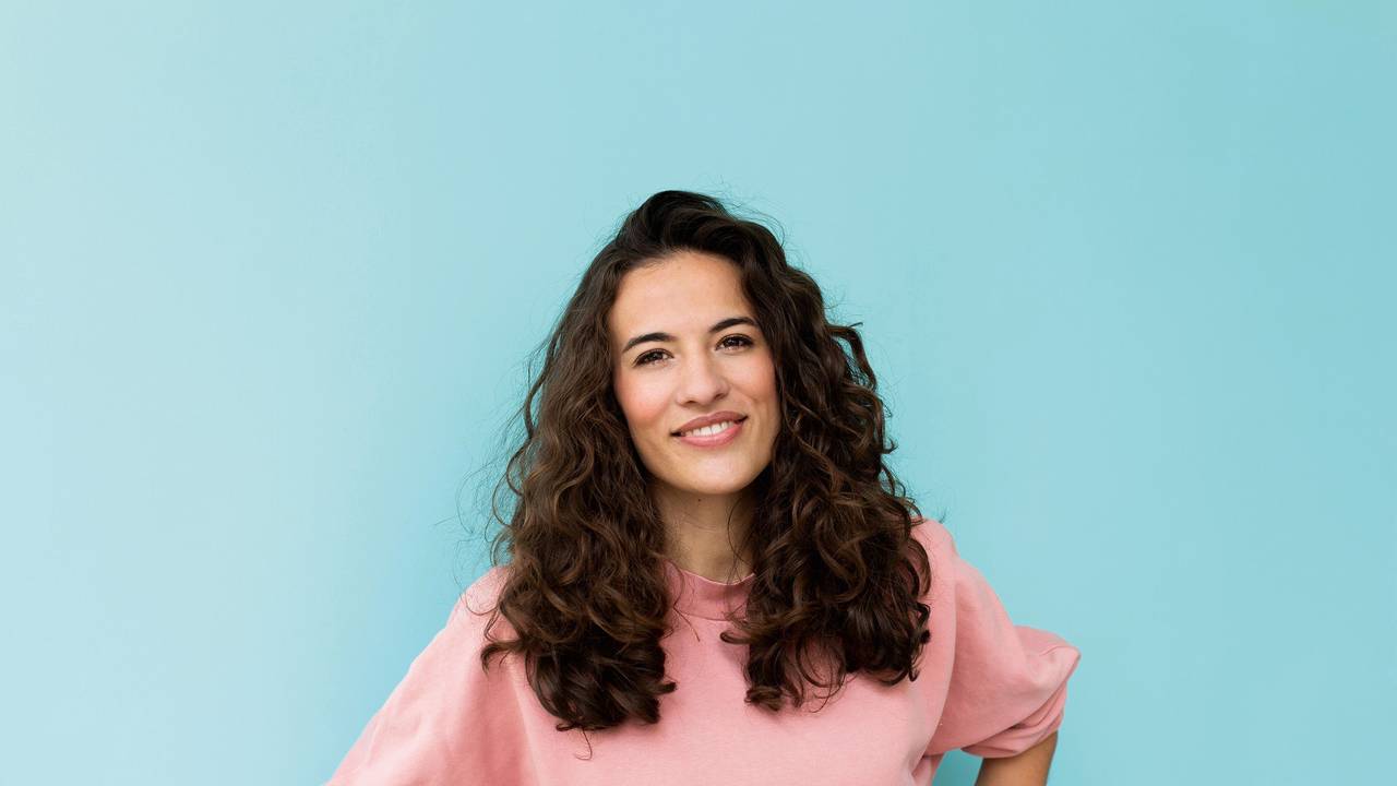 Moderatorin Mona Ameziane posiert mit leichtem Lächeln für die Kamera.