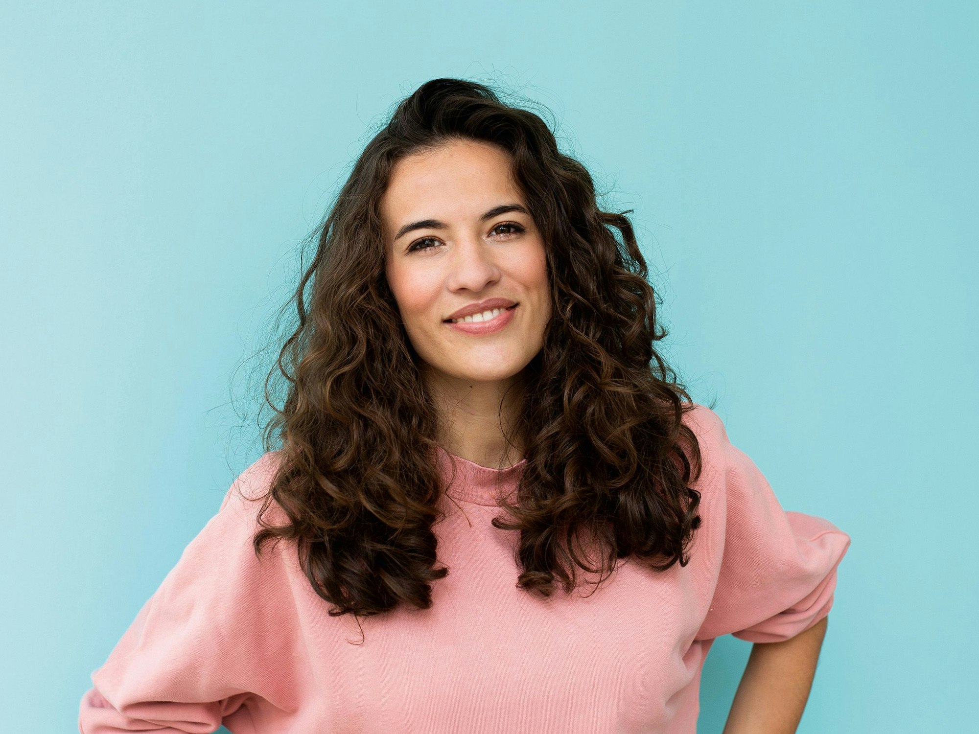 Moderatorin Mona Ameziane posiert mit leichtem Lächeln für die Kamera.