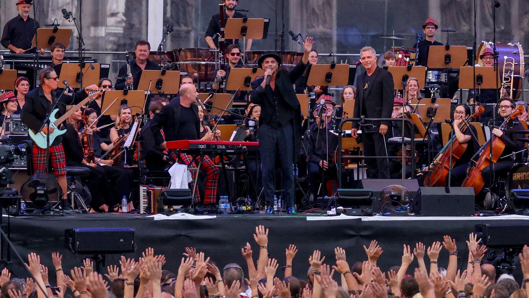 Brings und das Beethoven Orchester Bonn stehen vor dem Kölner Dom auf einer Bühne und spielen Musik.
