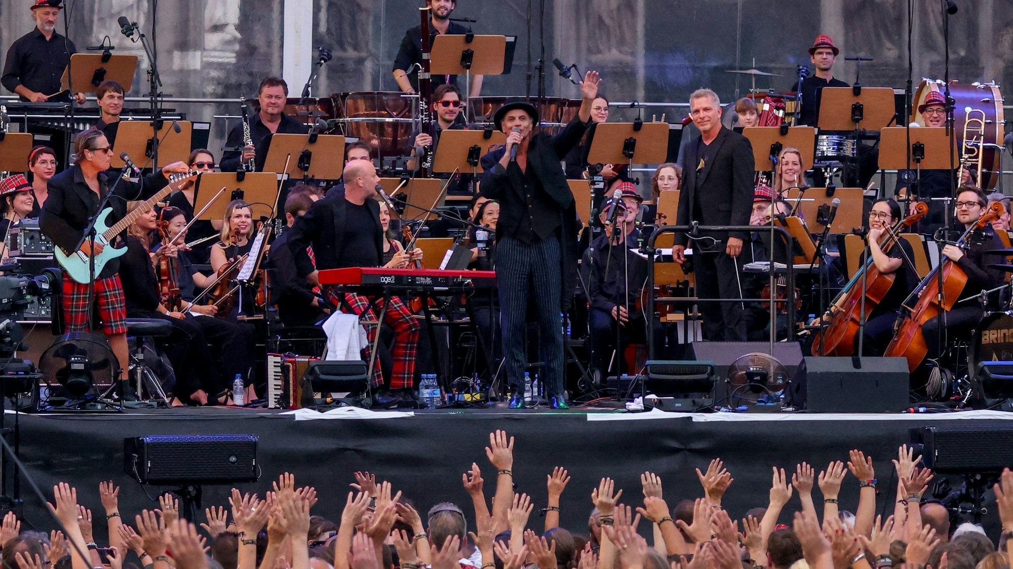 Brings und das Beethoven Orchester Bonn stehen vor dem Kölner Dom auf einer Bühne und spielen Musik.