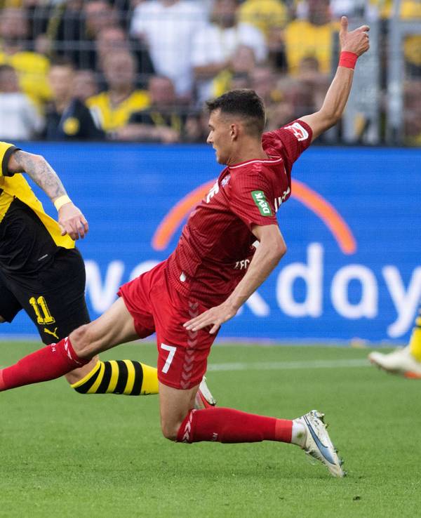 Dortmunds Marco Reus (M) und Dejan Ljubicic von Köln in Aktion.