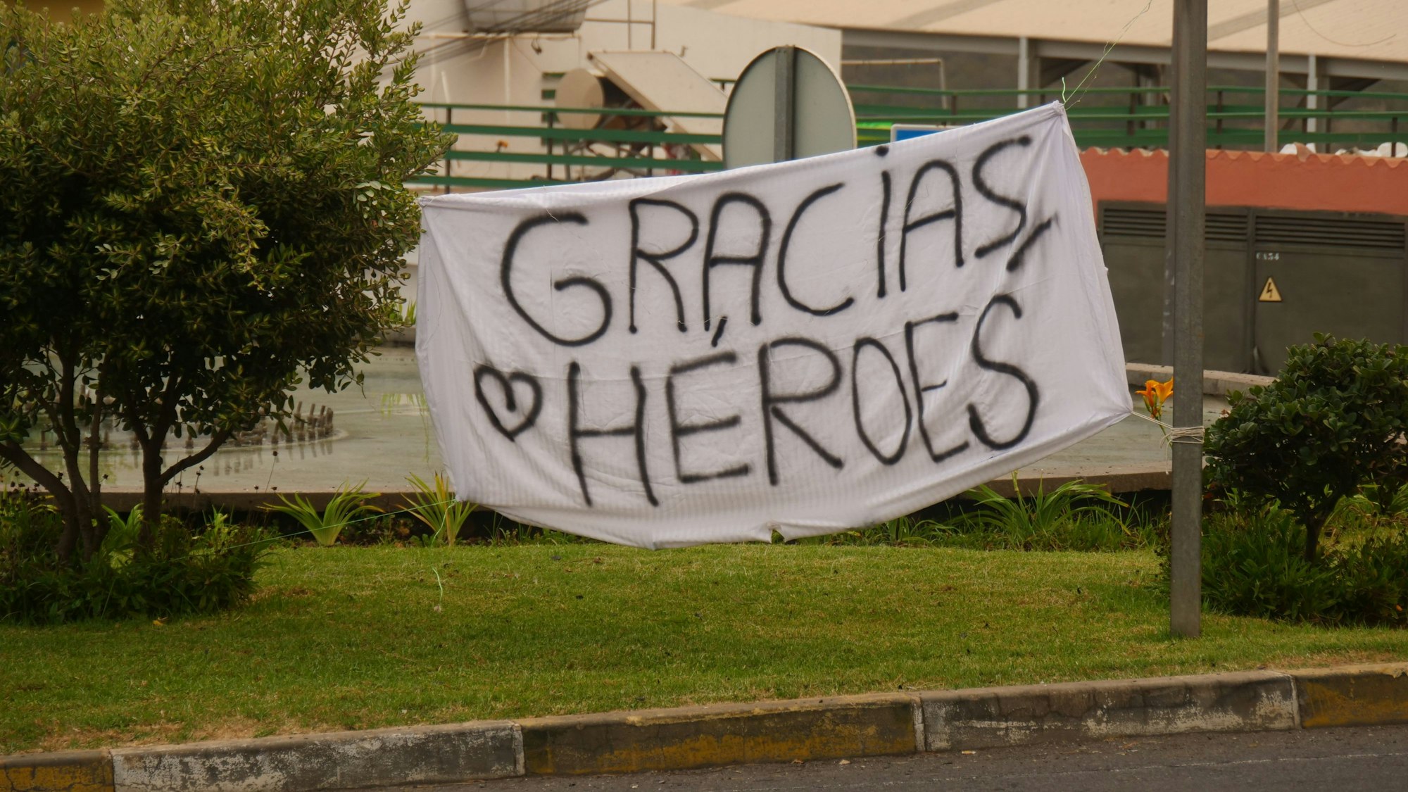 Ein Banner mit der Aufschrift „Gracias Héroes“ ist an einem Kreisverkehr auf Teneriffa gespannt.