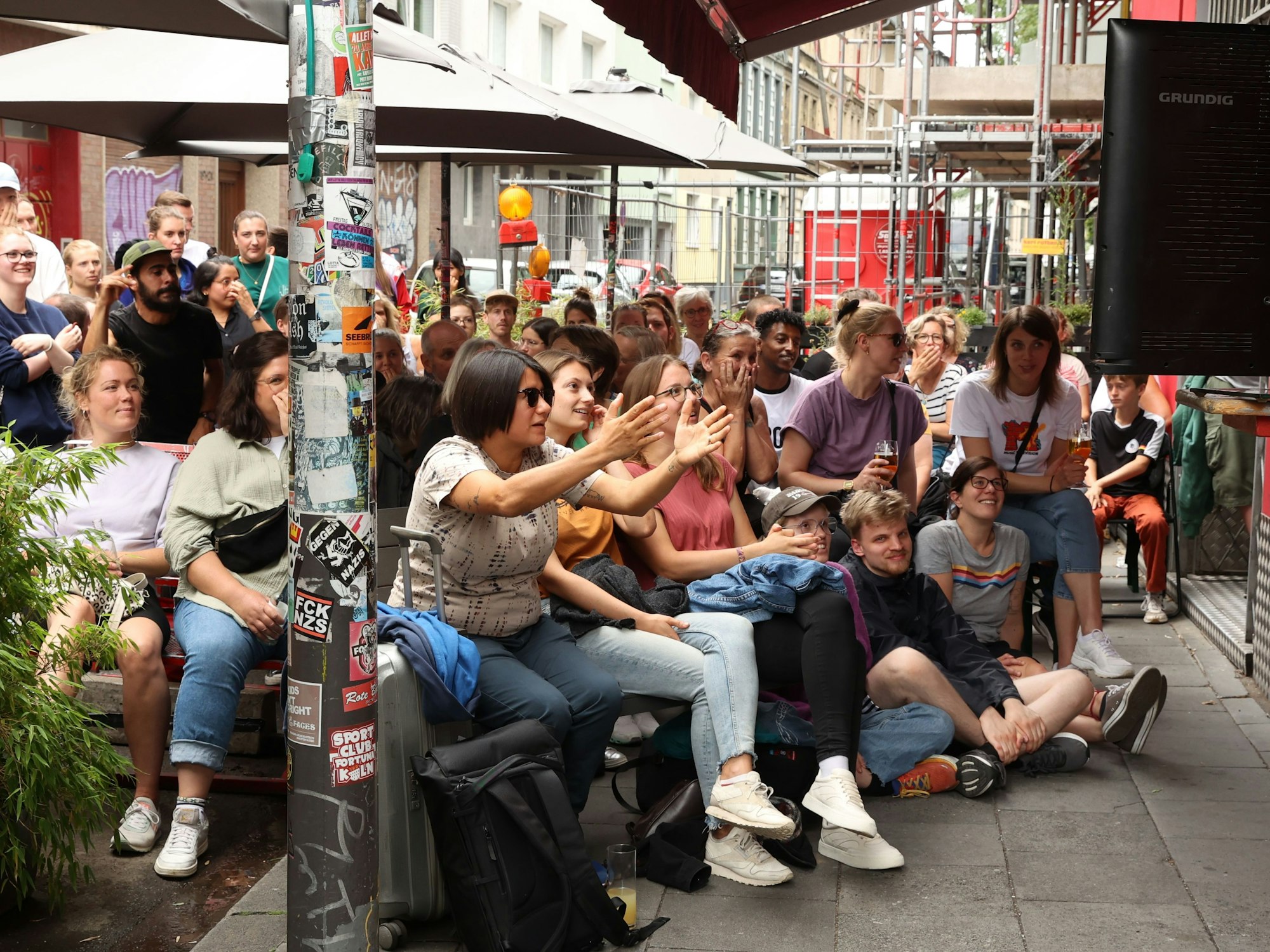 Gäste sitzen an der Kölner Kneipe Lotta und verfolgen die Spiele der deutschen Frauen-Nationalmannschaft.