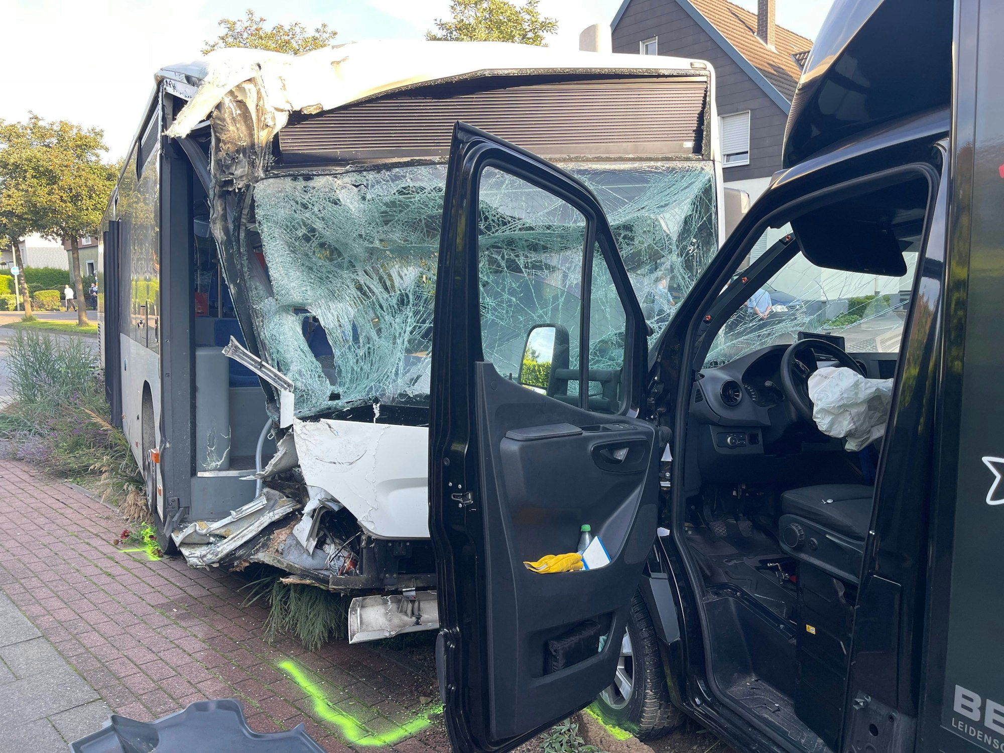 Ein beschädigter Linienbus (l.) steht nach einer Kollision mit einem Fahrzeug an der Unfallstelle.