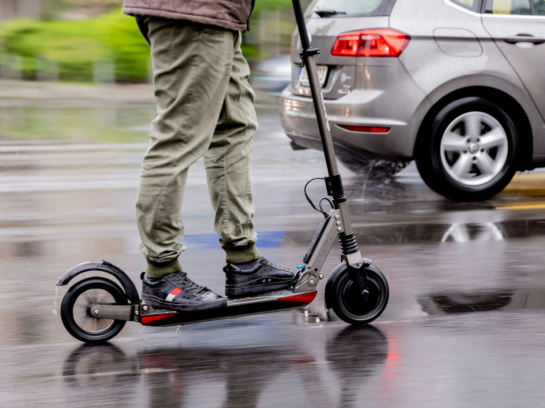 Ein Mann fährt mit einem E-Roller auf der Straße.