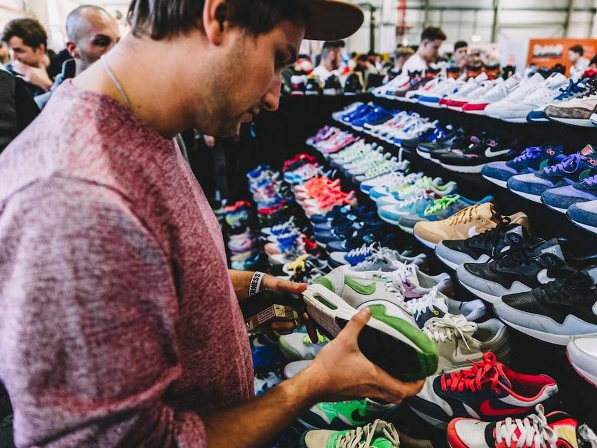 Ein Mann steht vor einem Sneaker bei der „Sneakerness“.