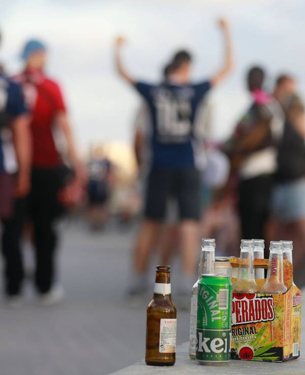 Feiernde auf Mallorca, im Vordergrund mehrere Bierflaschen.