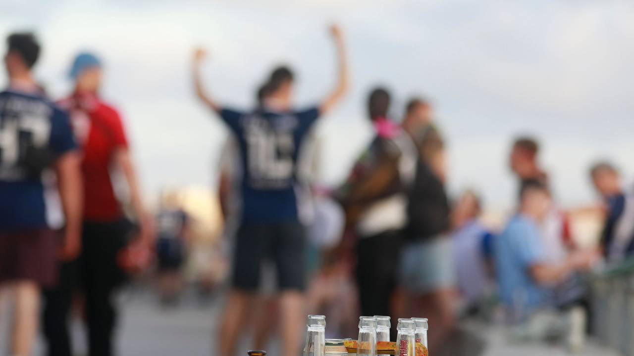 Feiernde auf Mallorca, im Vordergrund mehrere Bierflaschen.