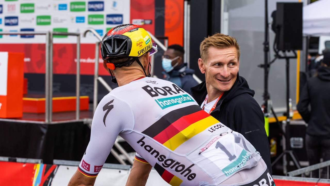 Nils Politt vom Team Bora-Hansgrohe (vorne) im Zielbereich mit dem ehemaligen Radprofi Andre Greipel.