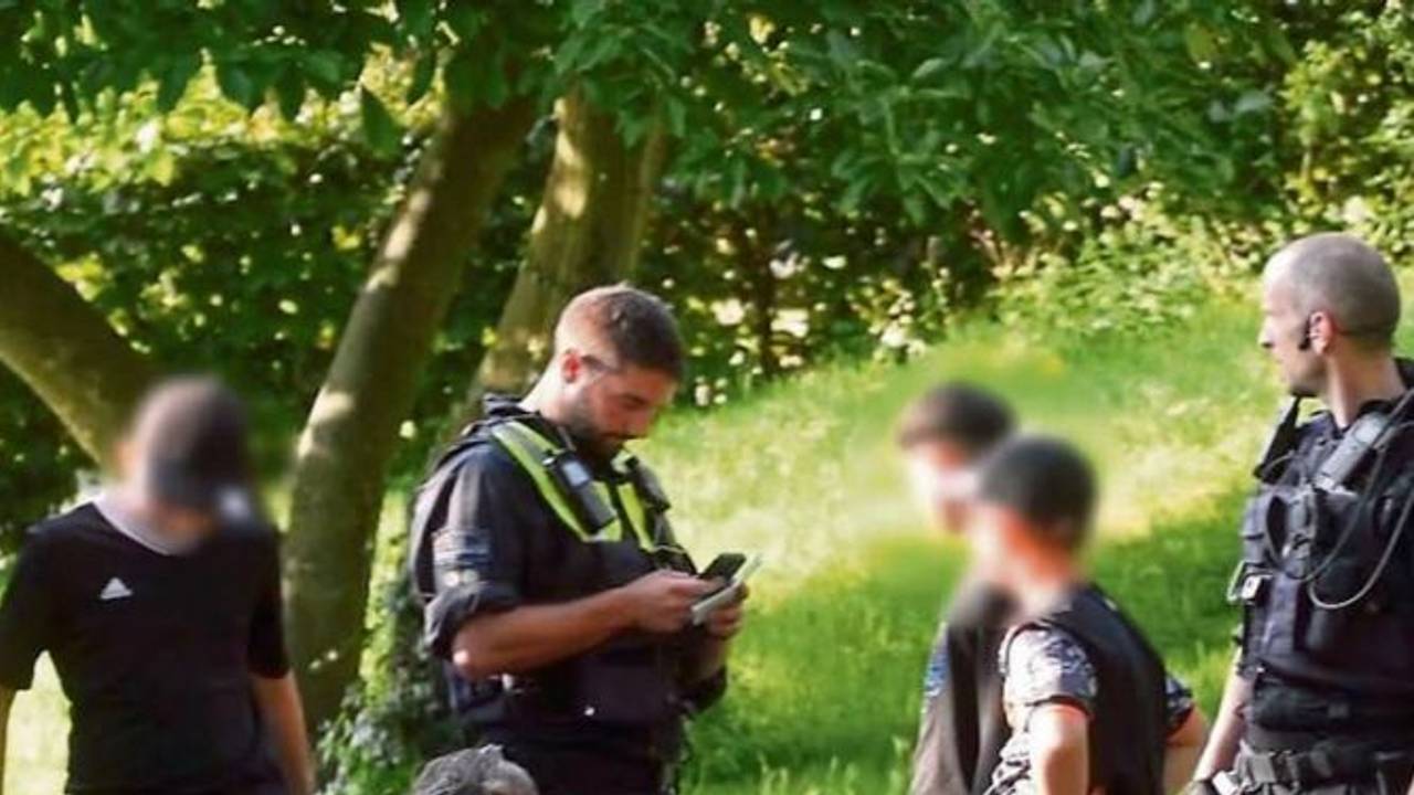 Polizisten durchsuchen drei Kinder von Kopf bis Fuß im Mülheimer Stadtpark.