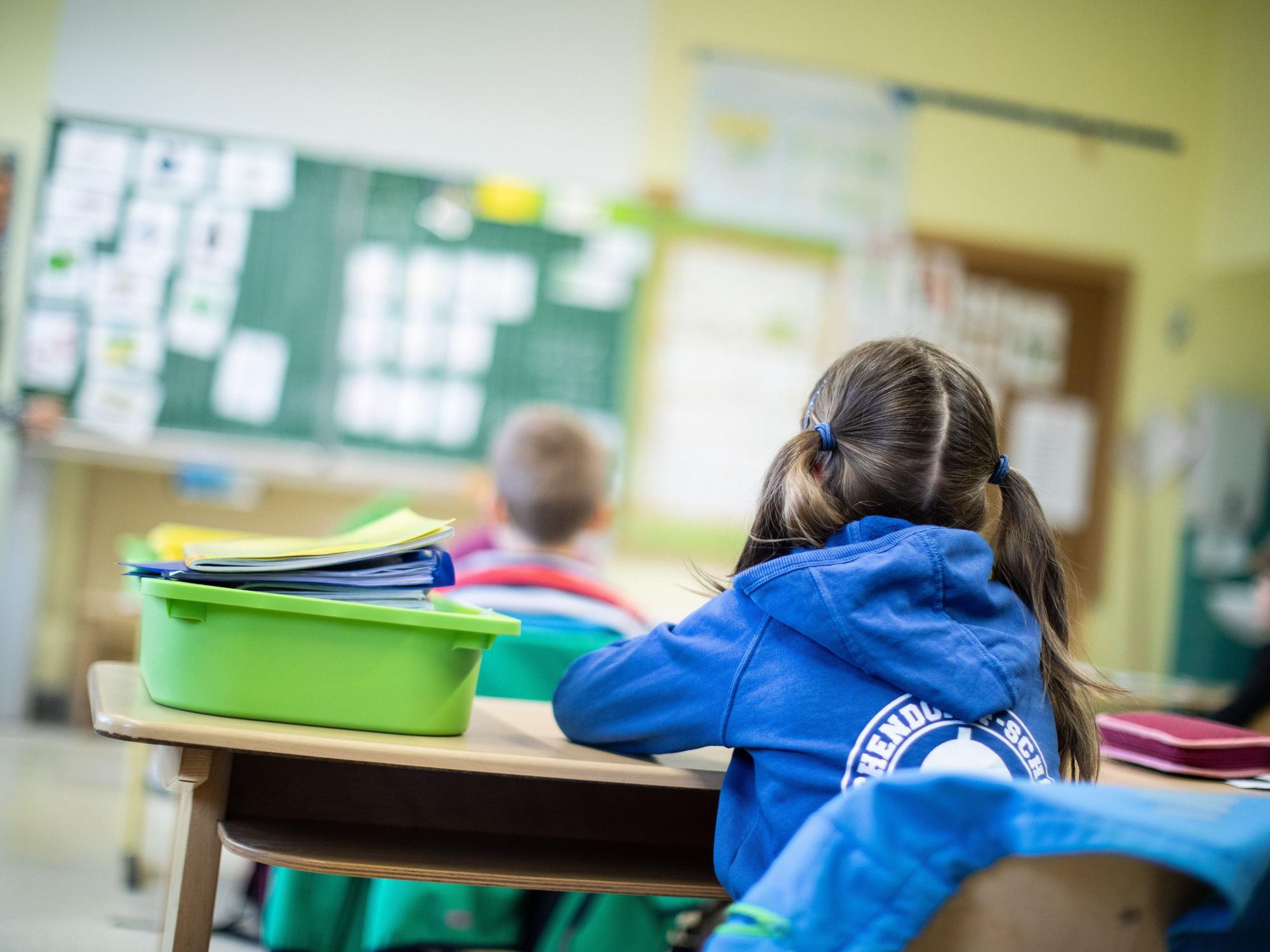 Schülerinnen und Schüler einer Grundschule sitzen in ihrem Klassenraum.