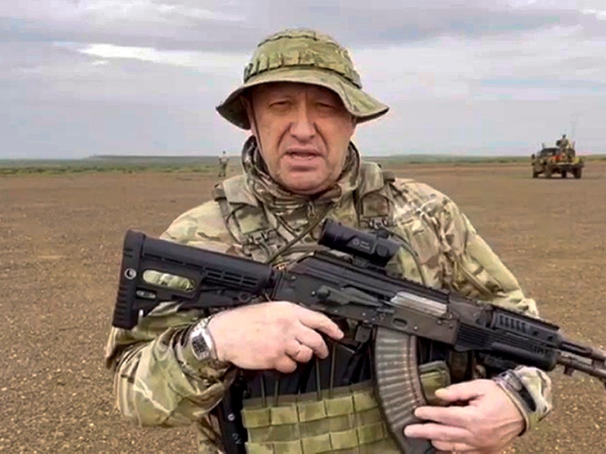 Jewgeni Prigoschin, Chef der Söldnergruppe Wagner, spricht in Tarnkleidung und mit Gewehr in der Hand an einem unbekannten Ort in eine Kamera.