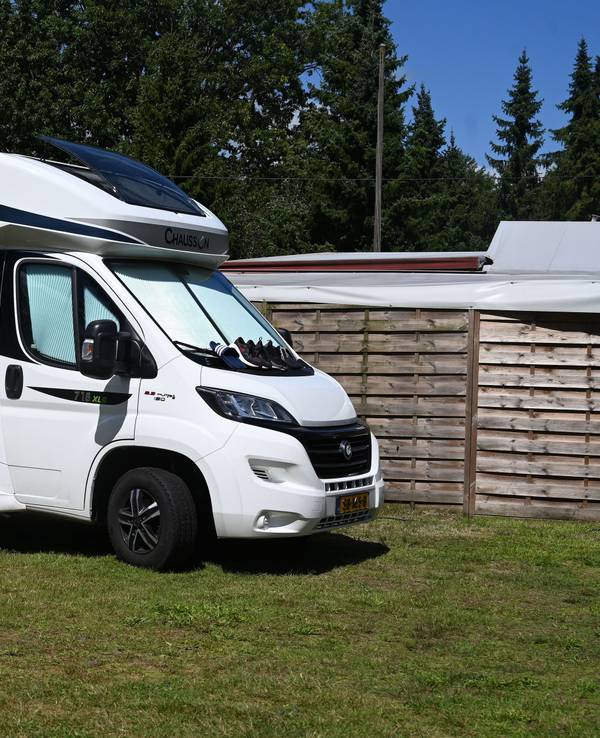 Ein Wohnmobil mit Tisch und Stühlen im Außenbereich steht auf dem Waldcampingplatz in Hepstedt.