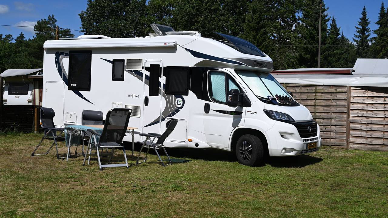 Ein Wohnmobil mit Tisch und Stühlen im Außenbereich steht auf dem Waldcampingplatz in Hepstedt.