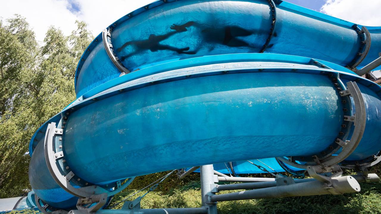 Zwei Personen rutschen eine Wasserrutsche runter.