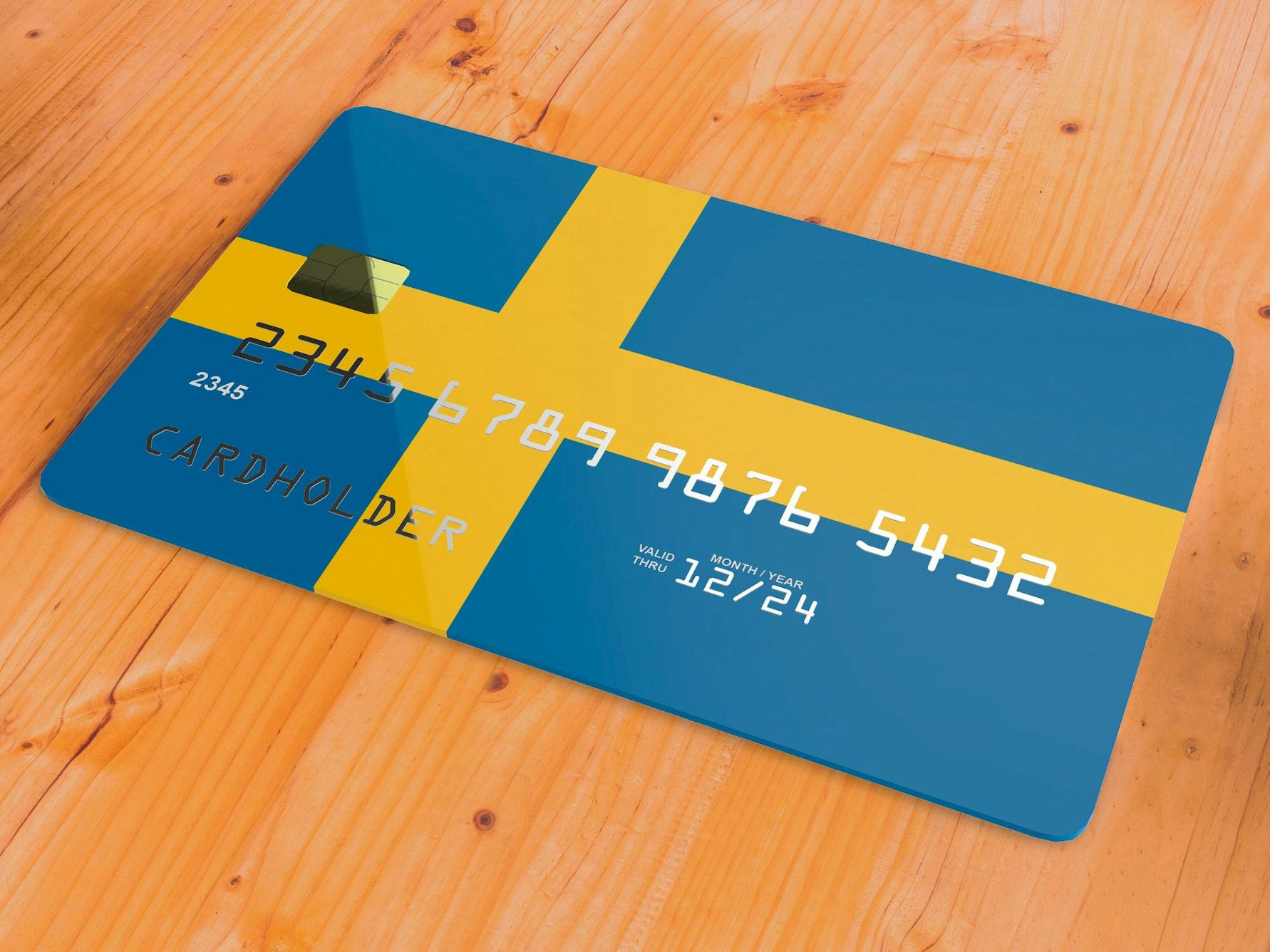 Eine Kreditkarte mit Schwedenflagge liegt auf einem Tisch.