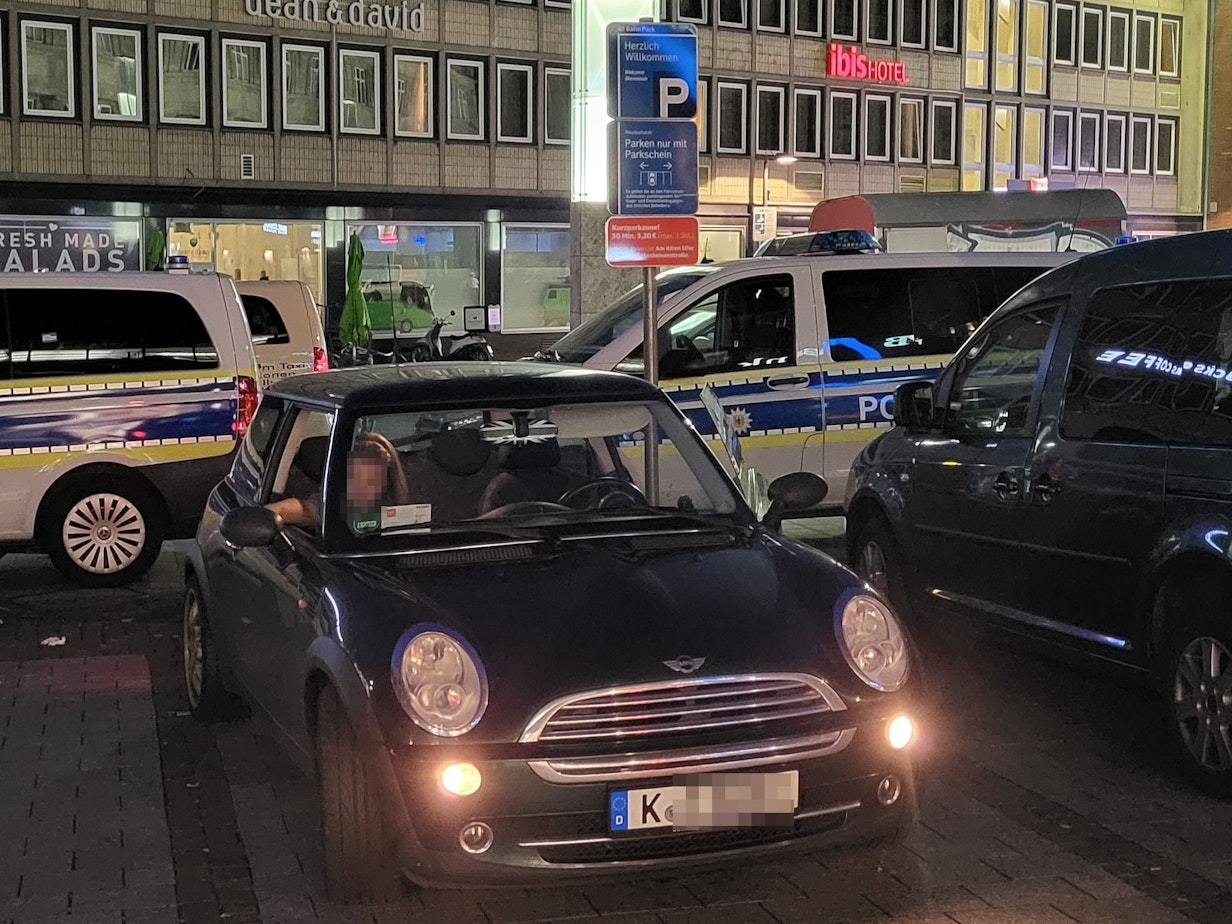 Ein Mini Cooper steht auf dem Bahnhofsvorplatz.