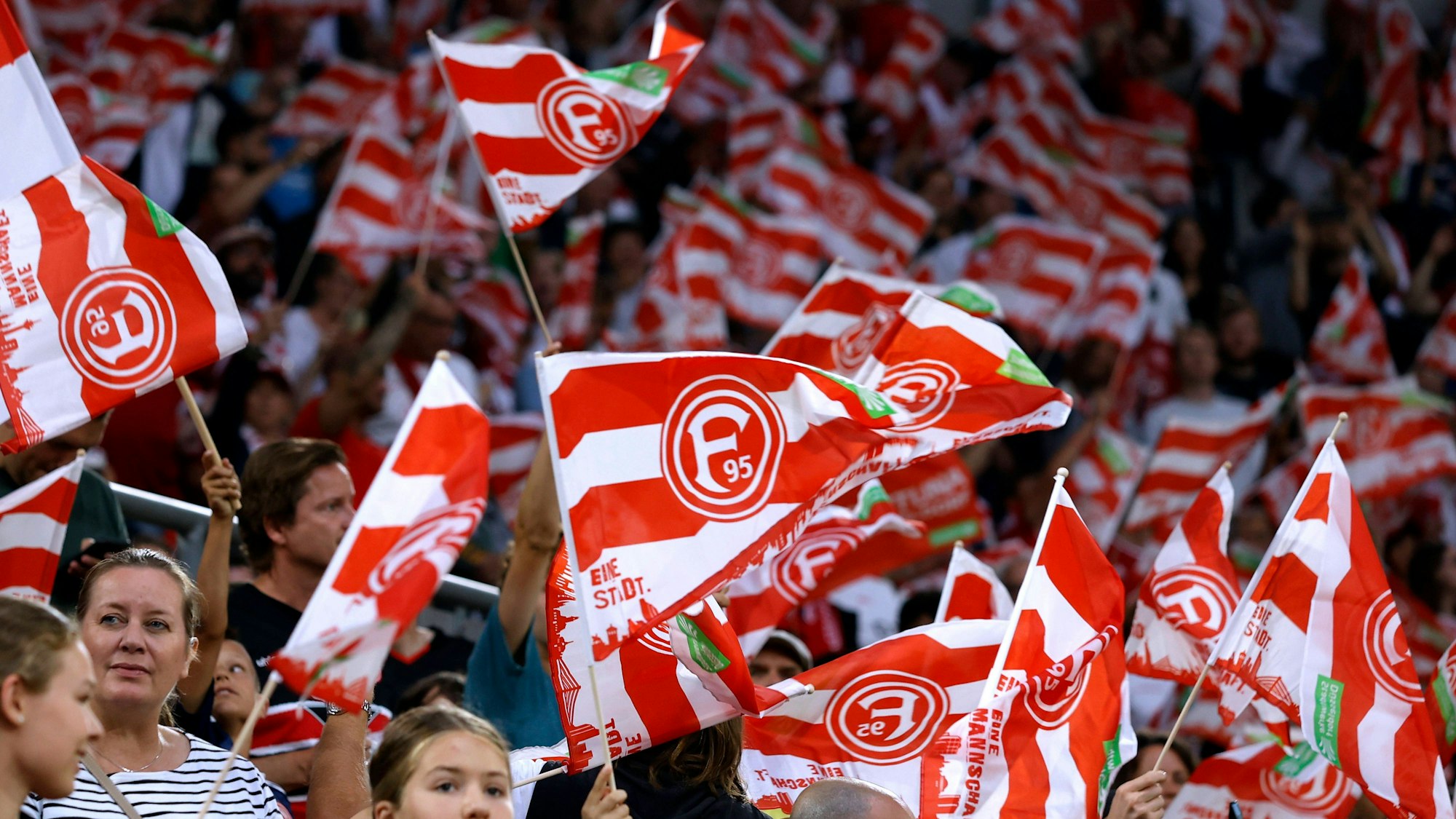 Fans von Fortuna Düsseldorf schwenken beim Heimspiel gegen Hertha BSC ihre Fahnen.