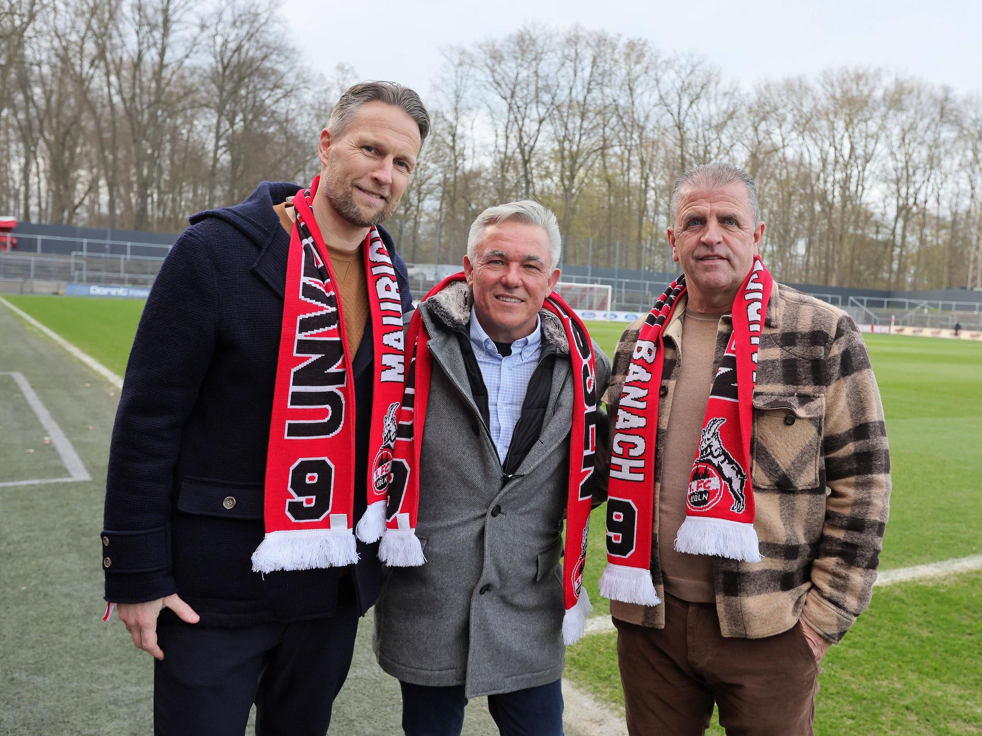 Alexander Bade, Olaf Janßen und Franz Wunderlich zu Gast posieren und tragen Schals mit der Aufschrift: „Unvergessen – Maurice Banach“.