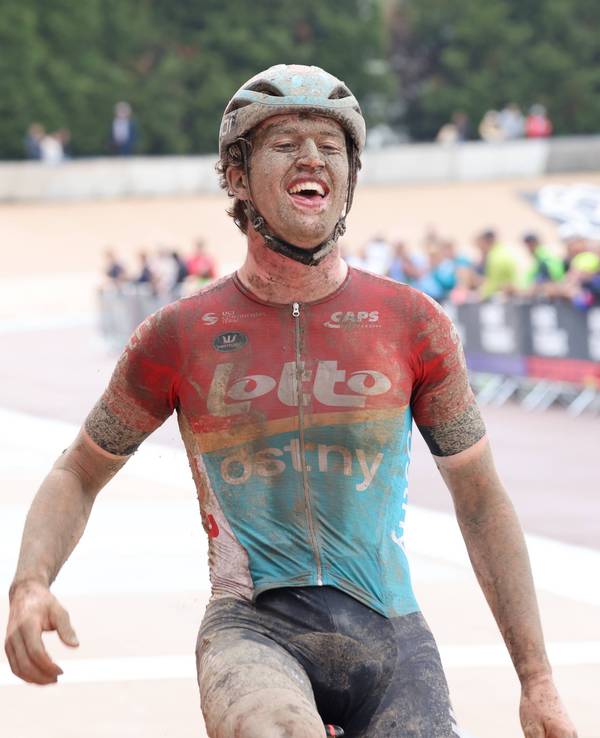 Tijl De Decker fährt beim U23-Rennen von Paris-Roubaix matschbeschmiert als Sieger über die Ziellinie.