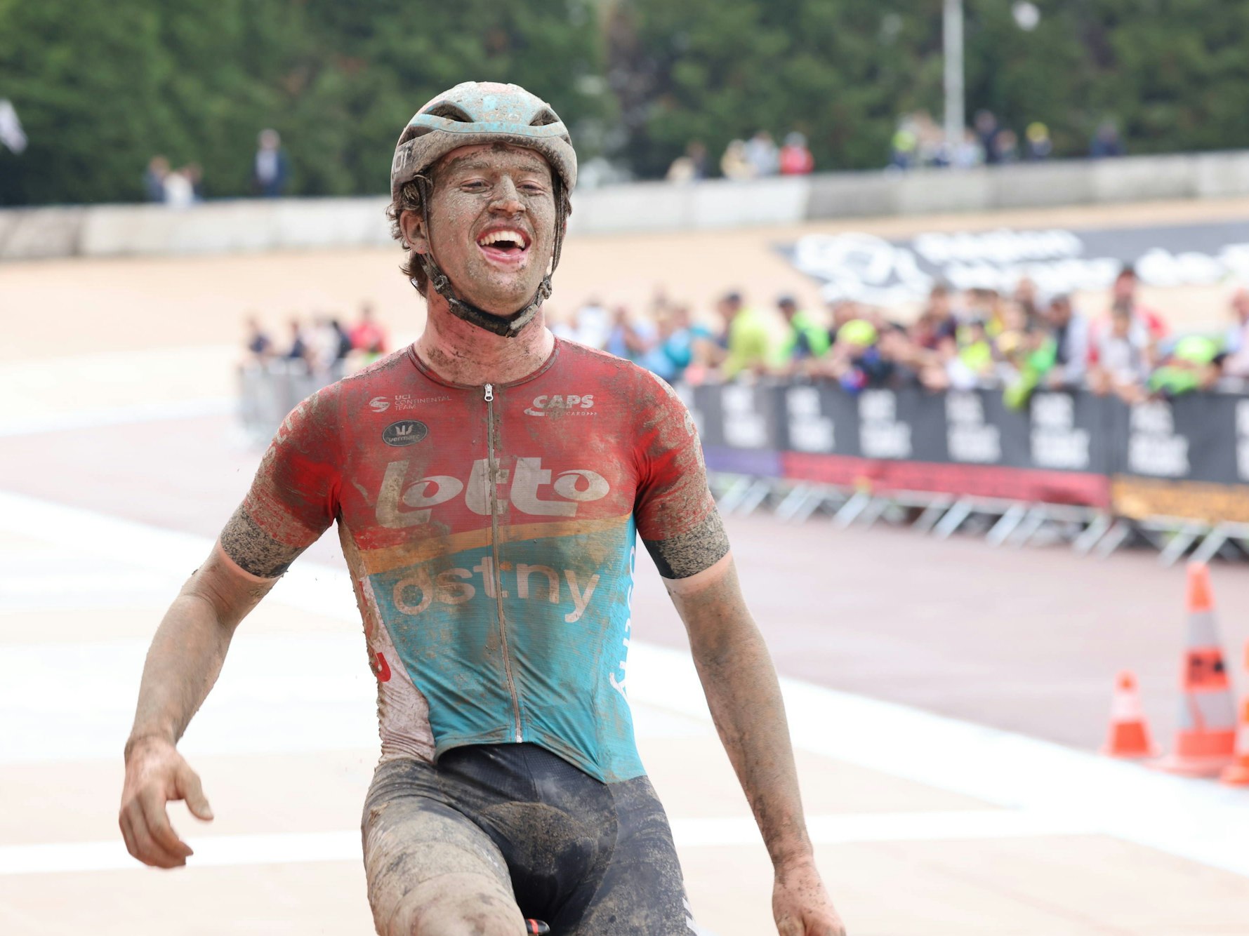 Tijl De Decker fährt beim U23-Rennen von Paris-Roubaix matschbeschmiert als Sieger über die Ziellinie.