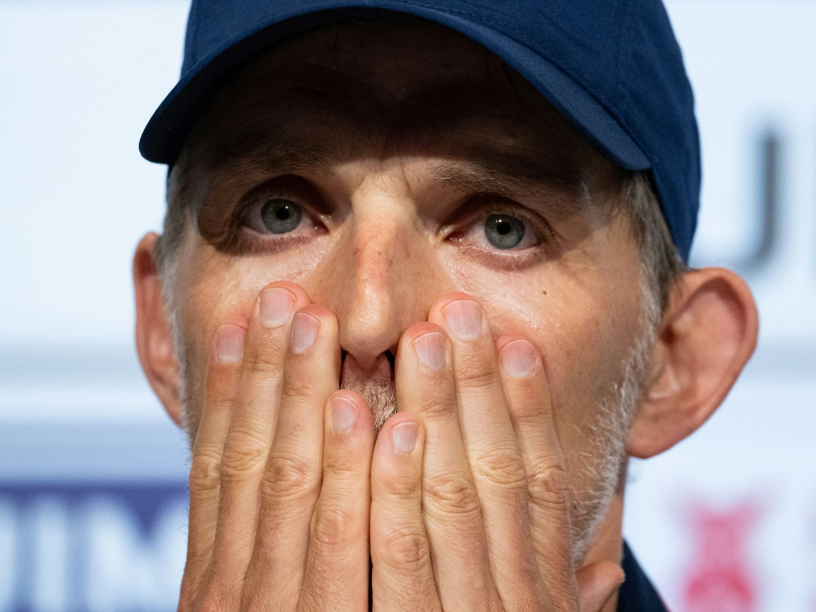 Thomas Tuchel hält bei einer Pressekonferenz die Hände vors Gesicht.