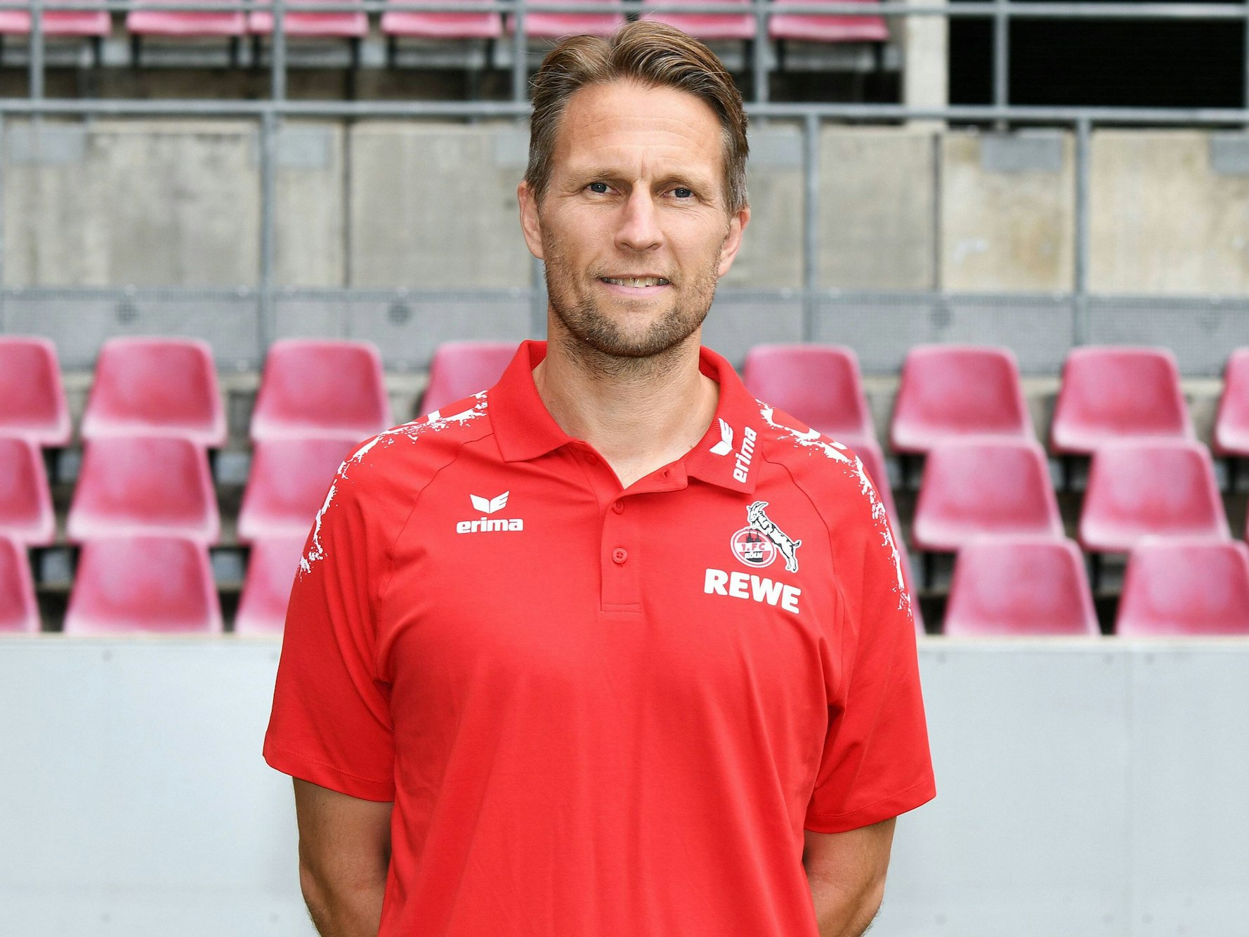 Alexander Bade hat die Arme hinter dem Rücken verschränkt und schaut in die Kamera.