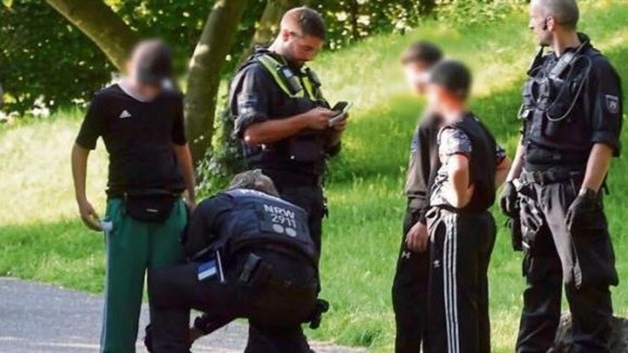 Polizisten durchsuchen drei Kinder von Kopf bis Fuß im Mülheimer Stadtpark-