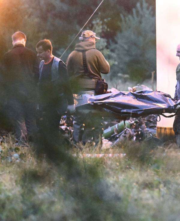 Menschen tragen einen Leichensack aus dem Wrack eines in Russland abgestürzten Privatjets, in dem auch Jewgeni Prigoschin gesessen haben soll.