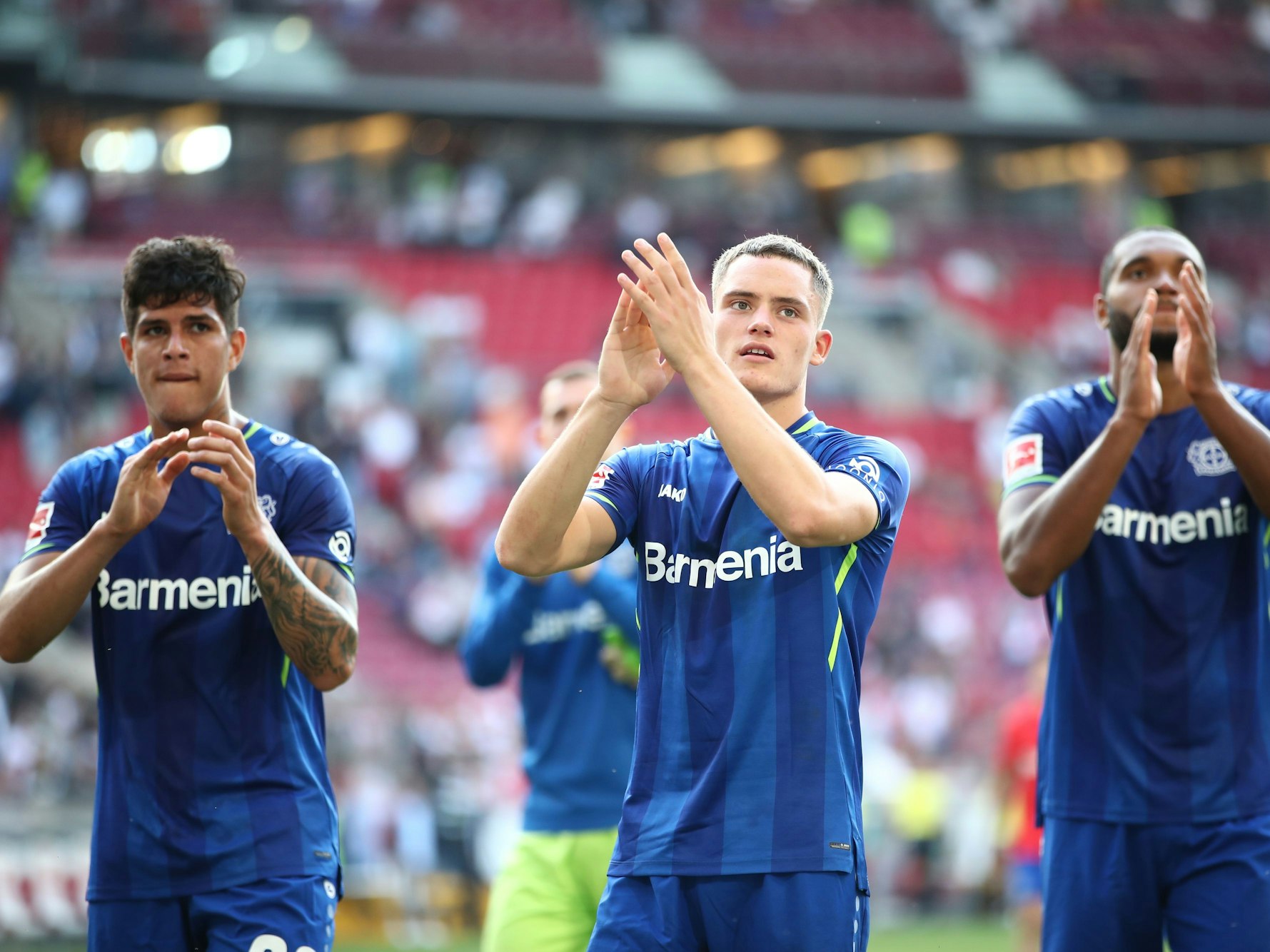 Piero Hincapie, Florian Wirtz und Jonathan Tah applaudieren den eigenen Fans nach einer Partie gegen den VfB Stuttgart am 19. September 2021.
