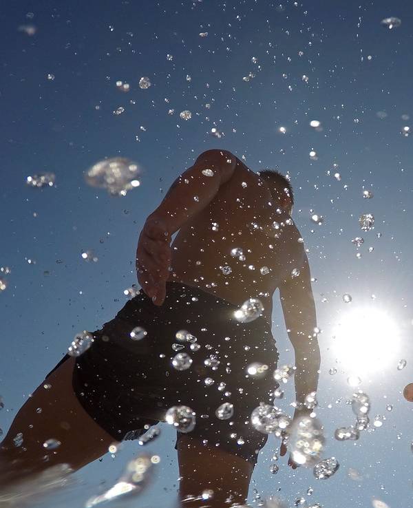 Menschen spielen mit einem Ball am Meer an einem warmen Sommertag am Strand Cala Major auf Mallorca.