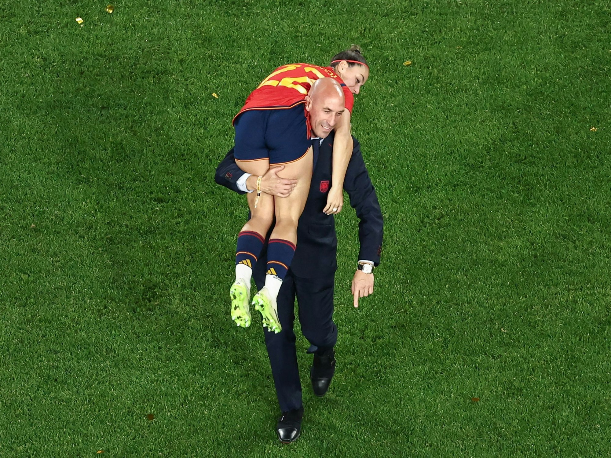 This picture taken on August 20, 2023 shows President of the Royal Spanish Football Federation Luis Rubiales carrying Spain's Athenea del Castillo Beivide on his shoulder as they celebrate winning the Australia and New Zealand 2023 Women's World Cup final football match between Spain and England at Stadium Australia in Sydney. (Photo by DAVID GRAY / AFP)
