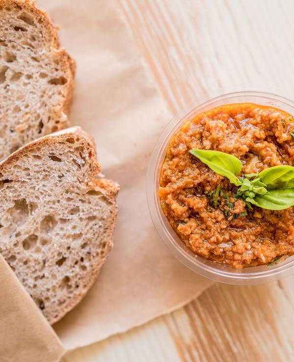 Das Bild zeigt zwei Brotschreiben und eine Schale mit roter Pesto-Sauce.